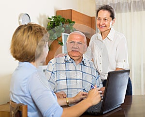 Senior couple with social worker at home