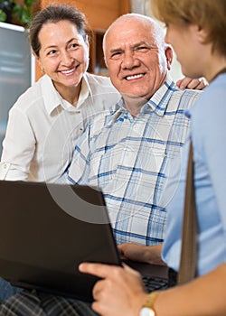 Senior couple with social worker at home
