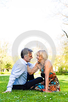 Senior couple during spring on a meadow in the city