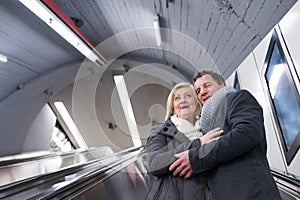 Senior couple standing at the escalator in Vienna subway
