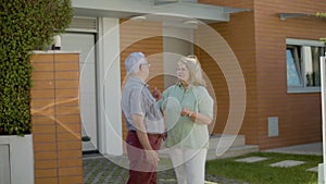 Senior couple standing outdoor and discussing buying new house
