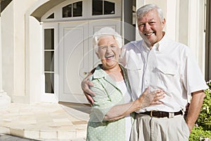 Senior couple standing outside house