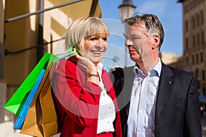 Senior couple strolling through the city shopping