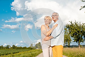 Senior couple in summer landscape looking into the future together