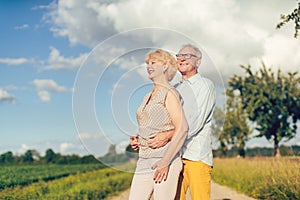 Senior couple in summer landscape looking into the future together