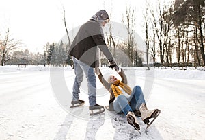 Senior couple in sunny winter nature ice skating.