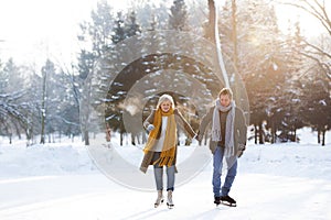 Senior couple in sunny winter nature ice skating.