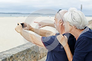 Senior couple taking picture on beach