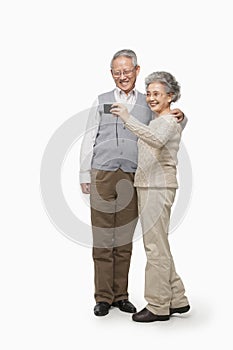 Senior couple taking picture with digital camera