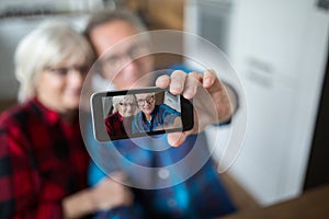 Senior couple taking selfie by mobile