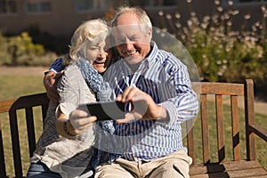 Senior couple taking selfie with mobile phone in the park