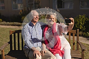 Senior couple taking selfie with mobile phone in the park