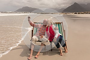 Senior couple taking selfie with mobile phone sitting