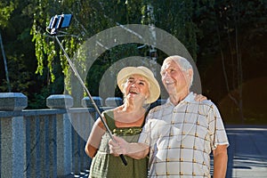 Senior couple taking selfie outdoors.