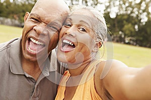 Senior Couple Taking Selfie In Park