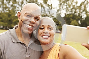 Senior Couple Taking Selfie In Park