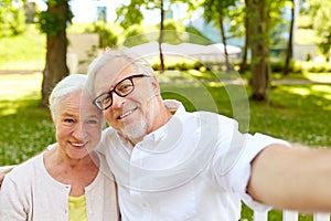 Senior couple taking selfie at summer park