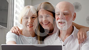 Senior couple and their daughter sitting at home talking via messenger Skype. Smiling laughing