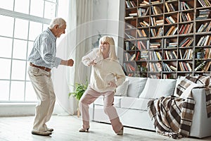 Senior couple together at home retirement concept dancing active dance playful