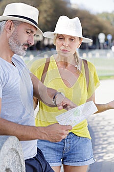 senior couple tourists looking at city map photo