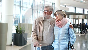 Senior couple traveling airport scene. Man and woman in waiting for your flight looking into the distance. Dressed