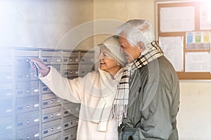 Senior couple unlocking apartment mailbox