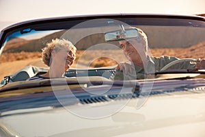 Senior couple on a US road trip, seen through car windscreen