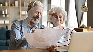 Senior couple use online banking on laptop planning family budget