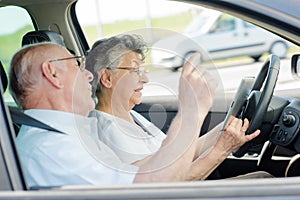 Senior couple using cellular while driving