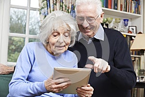 Senior Couple Using Digital Tablet At Home