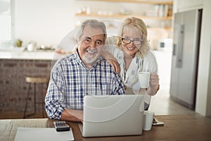 Senior couple using laptop at home