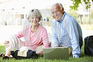 Senior couple using laptop outdoors