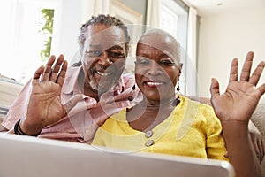 Senior Couple Using Laptop To Connect With Family For Video Call