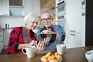 Senior couple using tablet at kitchen table