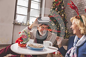 Senior couple using VR glasses to have video call with family on Christmas day
