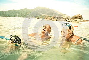 Senior couple vacationer having genuine fun on tropical beach photo