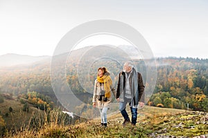 Senior couple on a walk in an autumn nature.