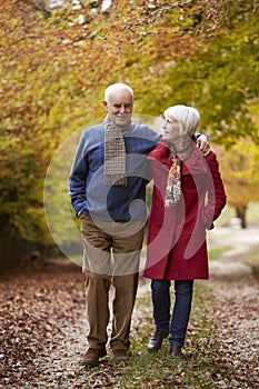 Senior Couple Walking Along Autumn Path