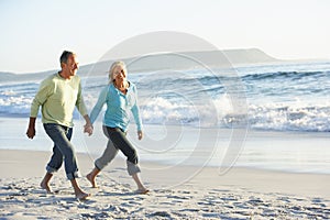 Senior Couple Walking Along Beach