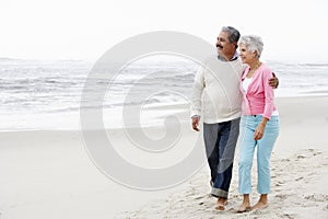 Senior Couple Walking Along Beach Together