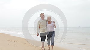 Senior Couple Walking Along Misty Beach