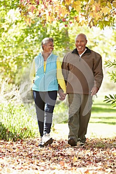 Senior Couple Walking Through Autumn Woodland