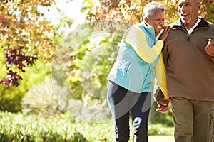 Senior Couple Walking Through Autumn Woodland