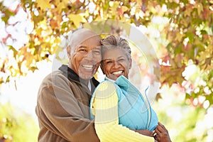 Senior Couple Walking Through Autumn Woodland