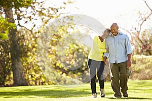 Senior Couple Walking Through Autumn Woodland