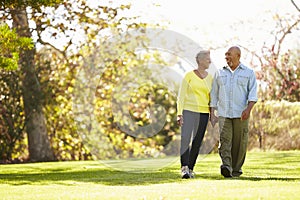 Senior Couple Walking Through Autumn Woodland