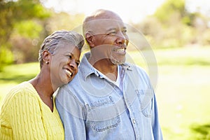 Senior Couple Walking Through Autumn Woodland