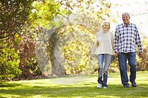 Senior Couple Walking Through Autumn Woodland