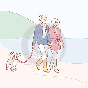 Senior couple walking on beach with dog