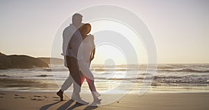 Senior couple, walking on beach and hug in sunset and married on holiday, outdoor and happy. Retirement, elderly and